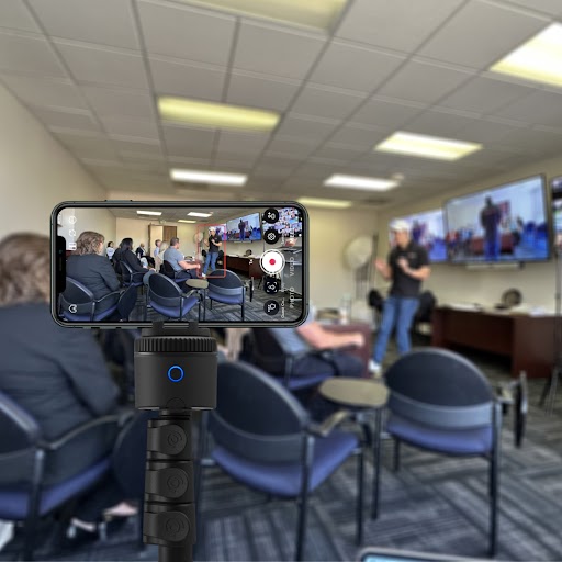 Premium Training | Pivo Pro smartphone mount with auto-tracking recording a video of a person presenting in a meeting room.