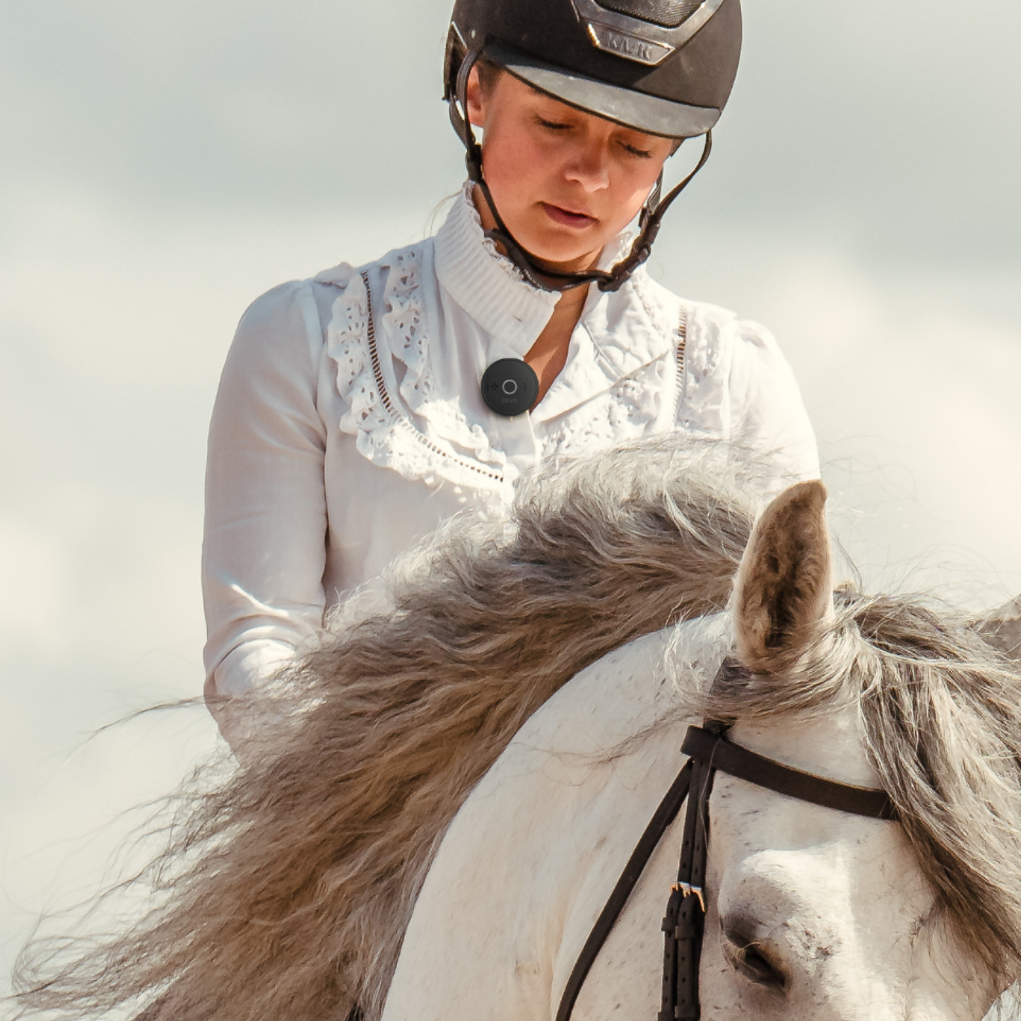 Wireless Bluetooth mic clipped on person riding a horse outdoors.